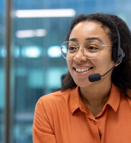 Confident customer support agent wearing headset smiling in modern office. Professional atmosphere conveys communication, service, and success in workplace. Ideal concept for call centers.